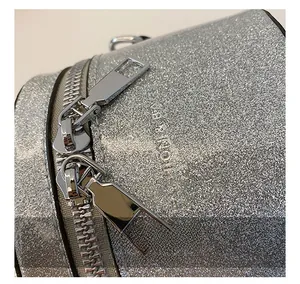 Détail des doubles fermetures éclair en métal sur un mini sac seau pailleté pour enfants