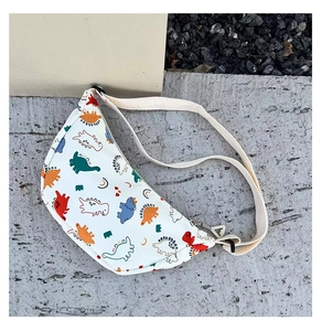 Close-up of white crossbody bag with colorful dinosaur patterns and metal zipper detail