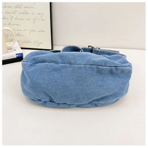 Detailed bottom view of light blue denim tote bag with curved structure and large capacity