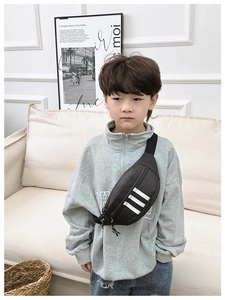 Detail of a boy wearing a black nylon chest bag with white stripes and adjustable strap