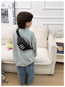 Detail of adjustable strap and plastic buckle on a nylon crossbody bag for kids