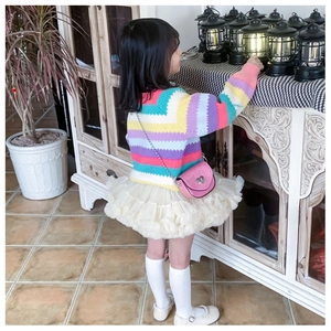 Detail of pink glitter heart bag paired with a striped sweater and tulle skirt