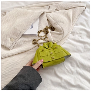 Détail du sac bandoulière vert herbe en forme de veste avec chaîne dorée et cuir grainé