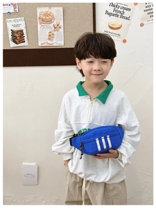 Close-up of kids blue nylon chest bag with white stripes and adjustable black strap