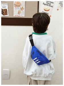 Rear view of a blue nylon kids chest bag with white stripes and adjustable strap