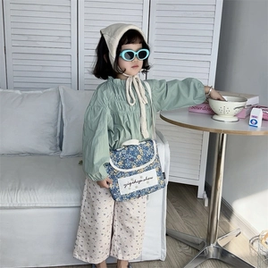 Children's fashion outfit with floral crossbody bag and mint green ruffled long sleeve top