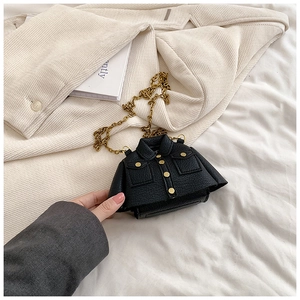 Détail d'un mini sac bandoulière noir en forme de veste avec texture litchi et chaîne or