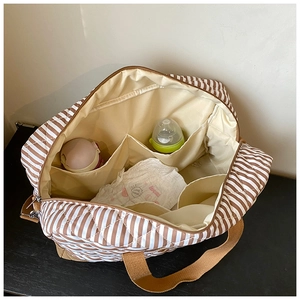 Vue intérieure du sac à langer à rayures avec plusieurs compartiments pour biberons
