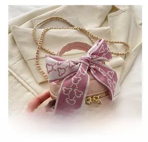 Gros plan d'un mini sac seau matelassé rose avec un foulard décoratif sur la poignée