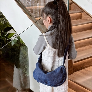 Kids vintage blue denim crescent tote bag worn as a casual crossbody satchel
