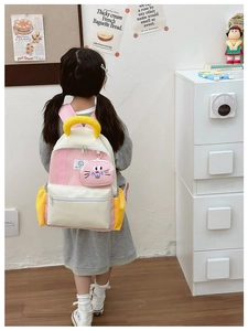 Detail view of pink and yellow patchwork kids backpack with cute rabbit coin purse hanging