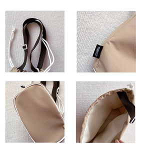 Detail view of khaki canvas kids crossbody bag showing adjustable strap and inner lining