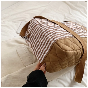 Détail du sac fourre-tout matelassé avec motif à vagues marron et bandoulière robuste