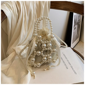 Detail der weißen Perlen-Eimertasche mit Satin-Kordelzug und elegantem Perlengriff