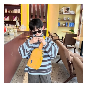 Detail of yellow canvas kids chest bag with FASHION lettering and blue side print