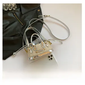 Détail d'un mini sac en paille tressée avec bordure argentée et pochette à cordon interne