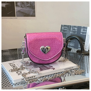 Close-up of pink glitter girls crossbody bag with silver heart-shaped metal twist lock