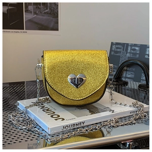 Detail of glitter crossbody bag showing silver heart twist lock and chain strap