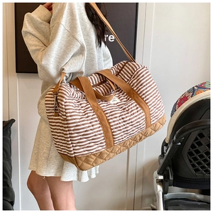 Détail du sac à langer rayé matelassé montrant sa grande capacité et sa bandoulière