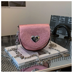 Detail of pink glitter heart-lock crossbody bag with silver chain strap and metallic finish