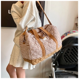 Détails d'un grand sac fourre-tout à rayures matelassé avec bandoulière réglable