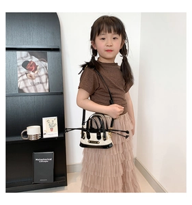 Détail du mini sac tissé en paille avec anses en cuir verni noir et intérieur à cordon