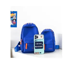 Detail view of mini blue nylon crossbody bags in two sizes for kids with orange accents