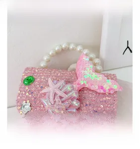 Detail view of pink sequin mermaid bag with pearl handle and shell decorations