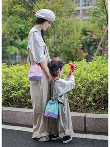 Detail view of colorful parent-child drawstring bucket bags in pink and purple canvas