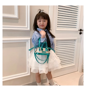 Détail du mini sac à main enfant turquoise avec paille tressée et plaque logo métal