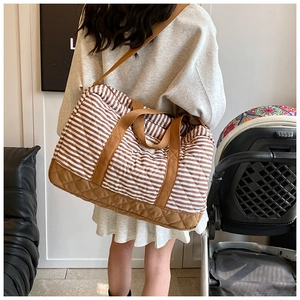 Détail d'un grand sac fourre-tout matelassé avec rayures marron blanc et bandoulière