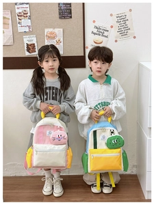 Detail of colorful patchwork school bags featuring cute cartoon pendant accessories