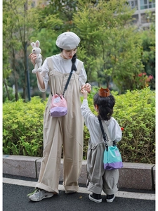Detail of color-block drawstring bucket bags with adjustable straps in outdoor park setting