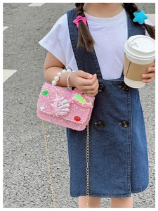Detail of pink sequin girls' bag featuring a pearl handle and mermaid sea star charms