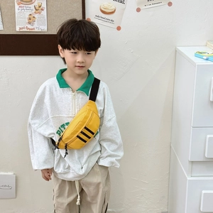 Yellow kids crossbody chest bag with black stripes and adjustable strap on model