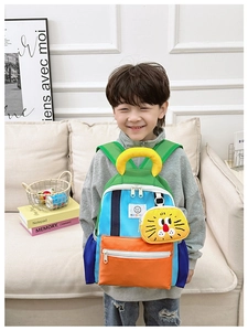 Detail of color-block kids backpack with detachable cartoon lion pouch on model