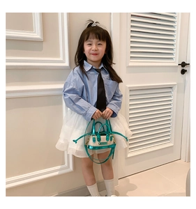 Vue détaillée du mini sac en paille tressée avec bordure verte et longues franges