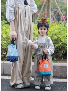 Detail of drawstring bucket bags with 'Fashion' label and contrast color design for kids
