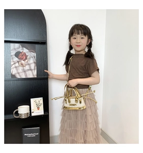 Détail du mini sac enfant en paille avec anses dorées et texture tressée crème