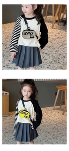 Dettaglio outfit per bambini con maglietta raglan beige, gonna a pieghe e borsa sport