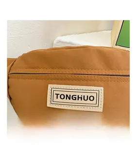 Vue détaillée du sac banane en toile camel avec étiquette TONGHUO et coutures de précision