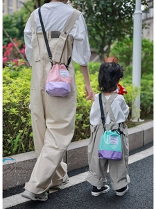 Detail of trendy color-block drawstring bucket bags for parent and child outings