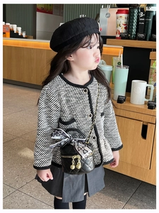 Fillette portant un mini sac matelassé avec veste en tweed et béret noir dans un café