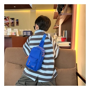 Close-up of blue nylon chest bag for kids featuring orange FASHION letter embroidery