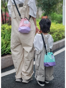 Outdoor shot of matching color-block drawstring bucket bags for parent and child