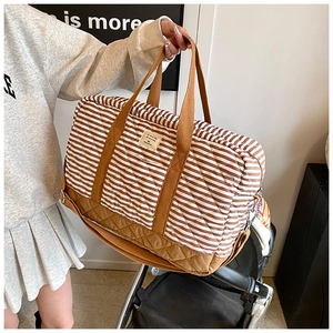 Détail du sac à langer à rayures matelassées avec poignées brunes et intérieur spacieux
