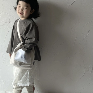 Minimalist beige canvas crossbody bag for children with white square pocket and drawstring