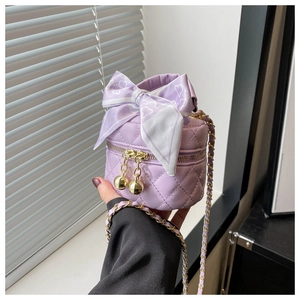 Détail du sac seau matelassé lavande avec nœud en cœur et bandoulière dorée