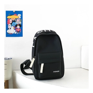 Detail of black mini chest bag for kids featuring white FASHION print and front zipper