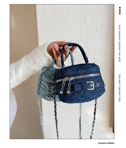 Detail of quilted denim mini bags in dark and light blue with silver chain straps